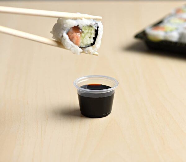 Sushi roll with soy sauce on a table.