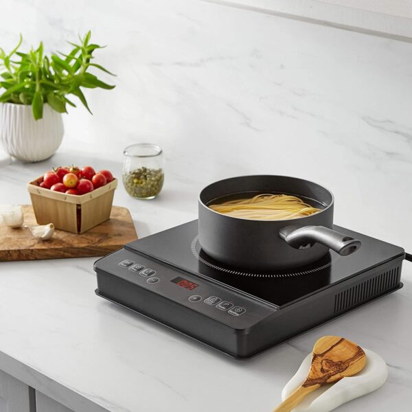 Black electric stovetop with pot of pasta.