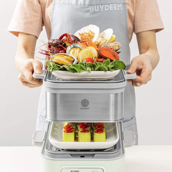 Person holding multi-tier steamer with food.