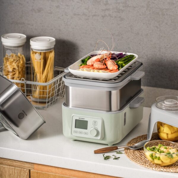 Green electric steamer with shrimp and vegetables.