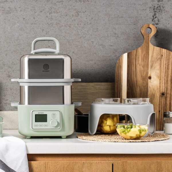 Electric steamer with food in bowls.