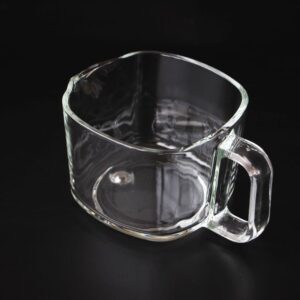 A glass cup sitting on top of a table.