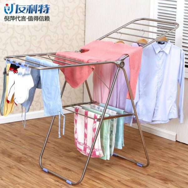 Stainless steel clothes drying rack with clothes.