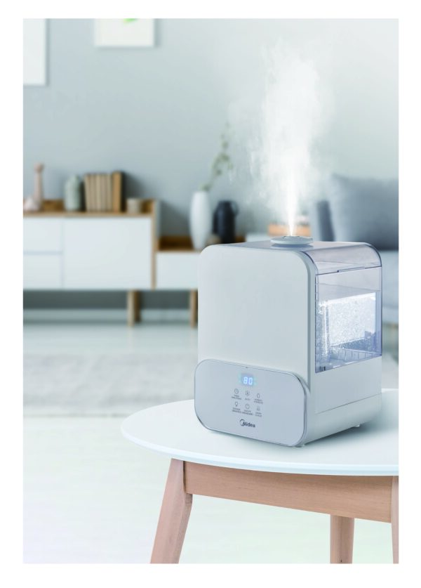 White humidifier with mist on table.